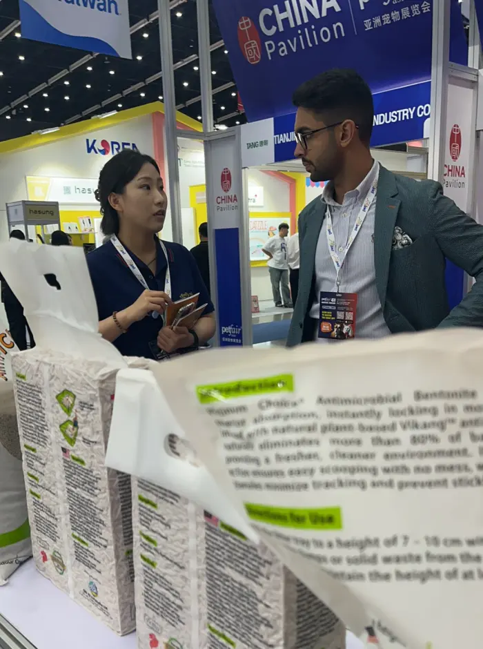 Exhibitor and buyer reviewing OEM specifications at a booth